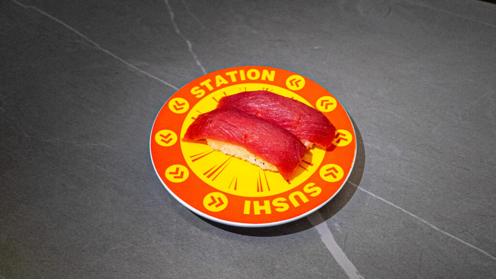 Fresh tuna sushi on orange Sushi Station conveyor belt plate at Japanese restaurant