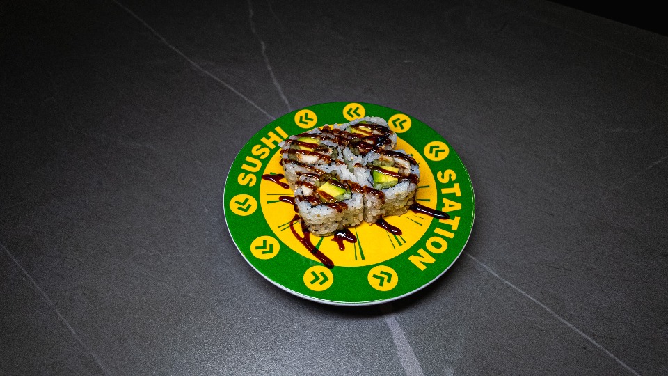 Sushi rolls with eel sauce on green and yellow "Sushi Station" plate at CROWDFAVORITES restaurant