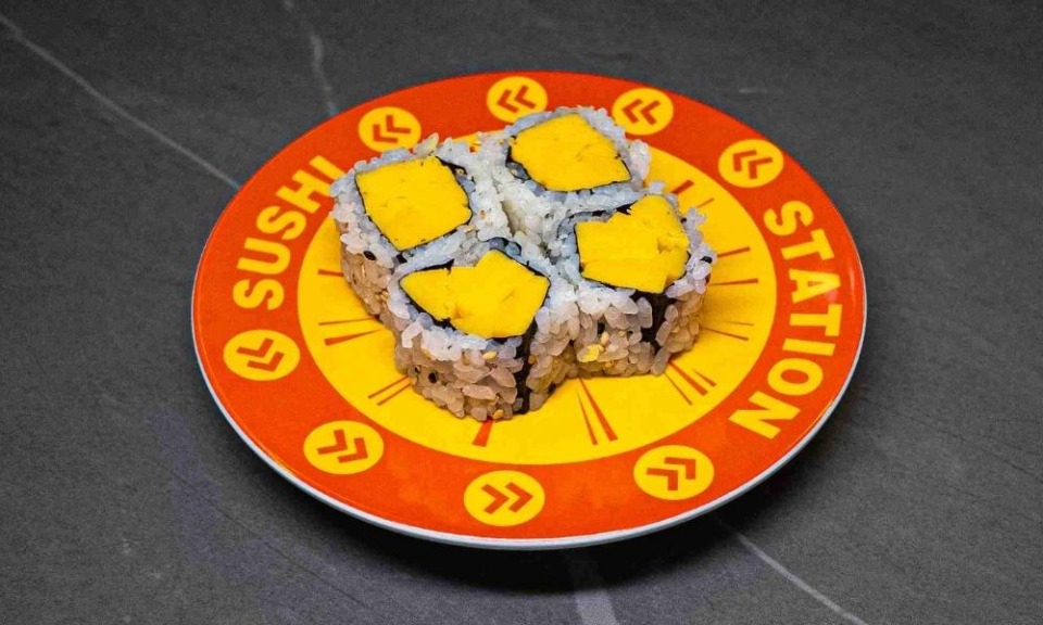 Sushi Station plate with four mango-topped sushi rolls, perfect for CROWDFAVORITES restaurant menu and sushi lovers seekin...