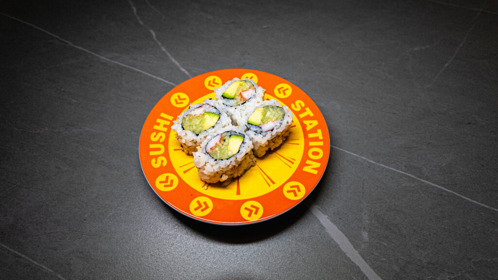 Sushi Station plate with avocado crab rolls on dark table, perfect for CROWDFAVORITES restaurant menu or delivery promo.