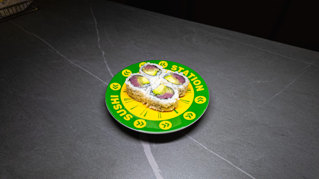 Sushi Station plate with four avocado-tuna rolls on dark marble table, perfect for CROWDFAVORITES restaurant menu.