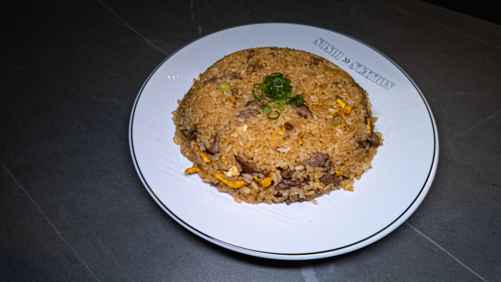 Beef fried rice with egg and green onions, served on a Sushi Station plate at CROWDFAVORITES restaurant