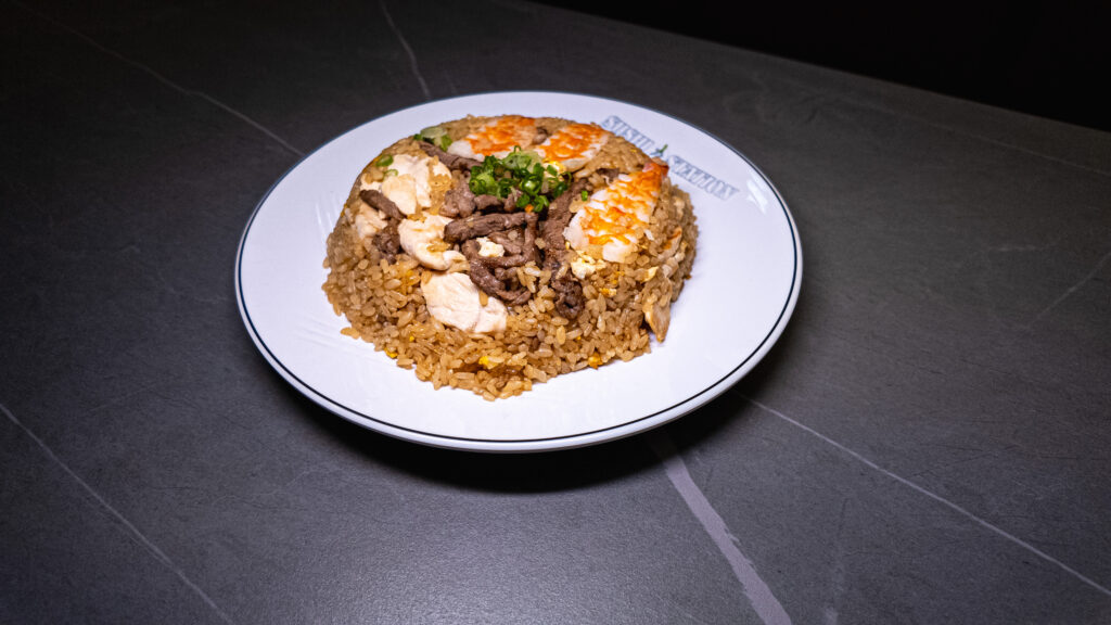 Beef and egg fried rice with green onions, served on a white plate at CROWDFAVORITES restaurant.