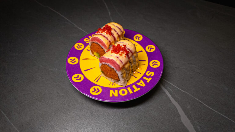 Tuna sushi rolls with tobiko and sauce on purple “STATION E” plate, served at CROWDFAVORITES restaurant.