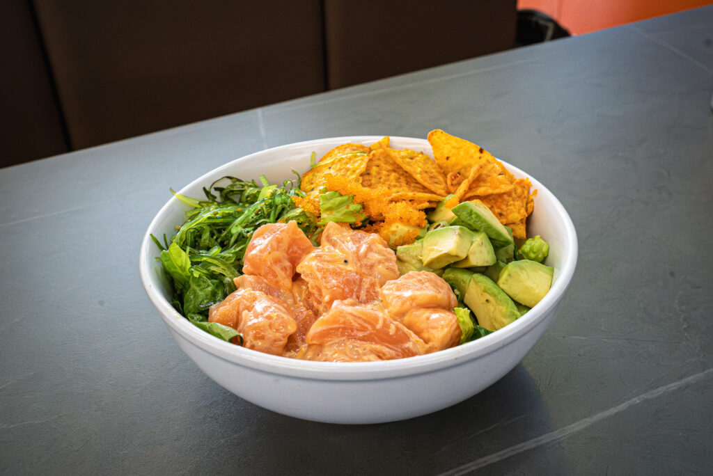 Salmon poke bowl with avocado, seaweed salad, and crispy chips at CROWDFAVORITES restaurant