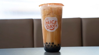Iced brown sugar boba tea in clear cup with "Nice Day" logo, served at CROWDFAVORITES restaurant with tapioca pearls at bo...