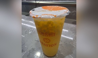 Sushi Station yellow boba drink in clear cup with orange lid, served at CROWDFAVORITES restaurant