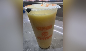 Fresh orange juice in branded Sushi Station cup, served at CROWDFAVORITES restaurant for a refreshing dining experience.